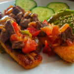 Plantains cut lengthwise, fried and served with some cooked beef