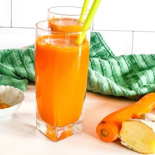 A picture of two glasses of carrot juice with turmeric and ginger.