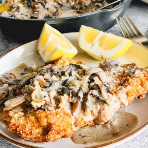 Air fryer chicken schnitzel or cutlets with mushroom sauce and slices of lemon