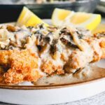 Air fryer chicken cutlets or schnitzel served on a plate with mushroom gravy and sliced lemon
