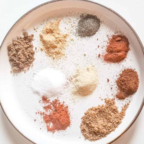 A plate of spices needed to make homemade burger seasoning.