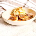 A picture of a plate of air fryer bananas served with ice-cream for dessert.
