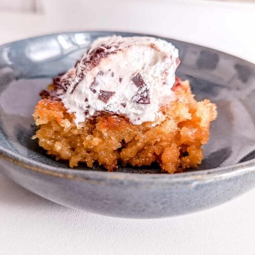 A plate with some malva pudding and ice cream on top.