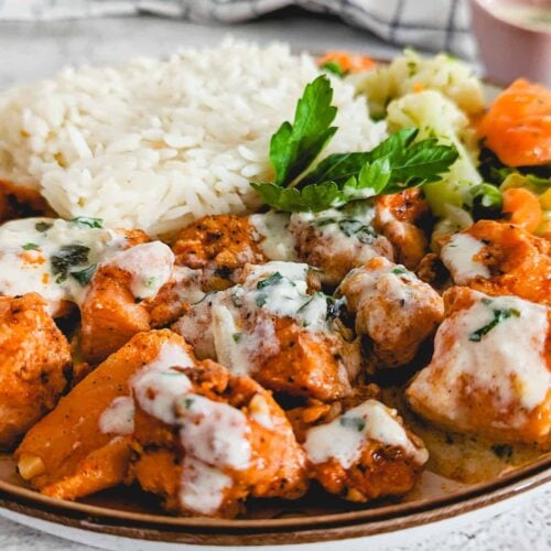 Air fryer salmon bites served on a plate with some rice.
