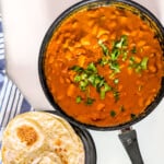 Butterbean curry in a cooking pan with a side of rotis.