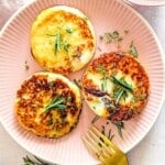 A close-up shot of crispy, golden-brown fried goat cheese slices arranged neatly on a plate.