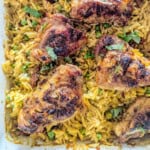 Chicken and orzo in a casserole dish with peas.