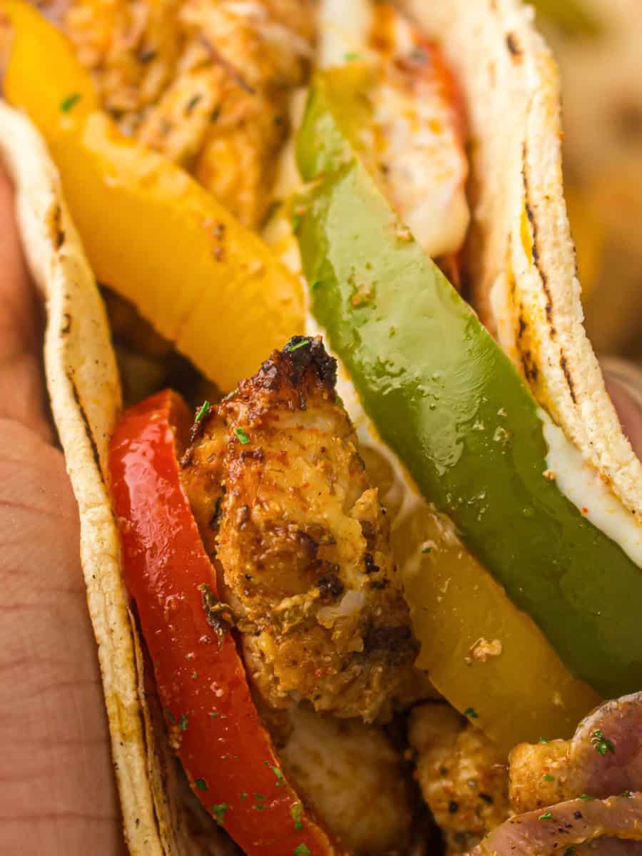 Chicken fajitas with colorful bell peppers wrapped in a tortilla.