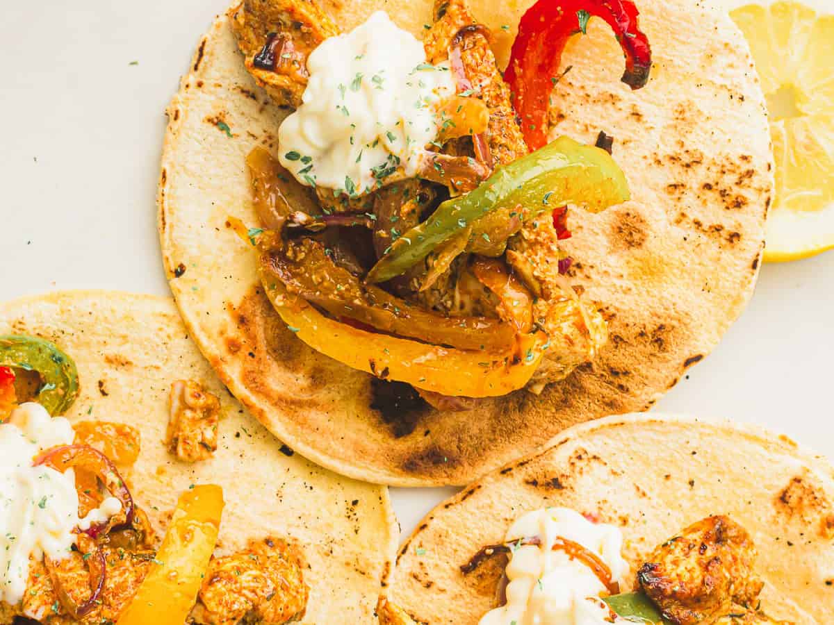 A top-down picture of air fryer chicken fajitas served on tortilla wraps.