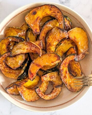 Top-down picture of air fryer acorn squash slices served in a bowl.