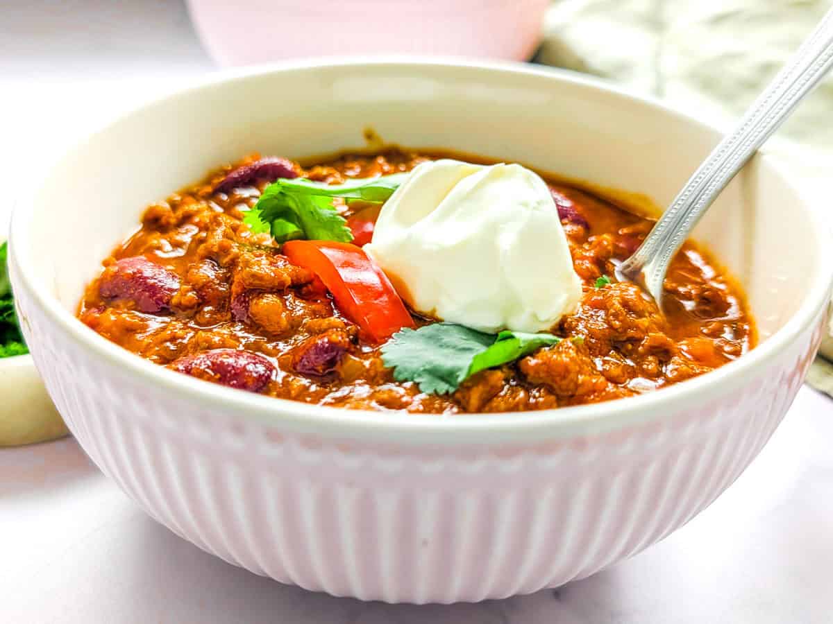 Chili con carne served in a pink bowl.