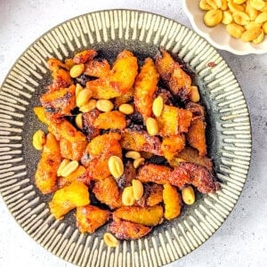 Spicy fried plantain (kelewele) on a plate served with peanuts.