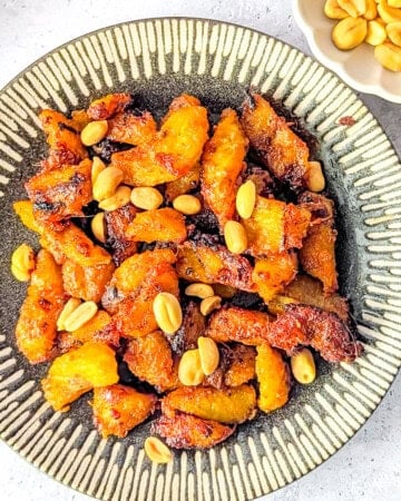 Spicy fried plantain (kelewele) on a plate served with peanuts.
