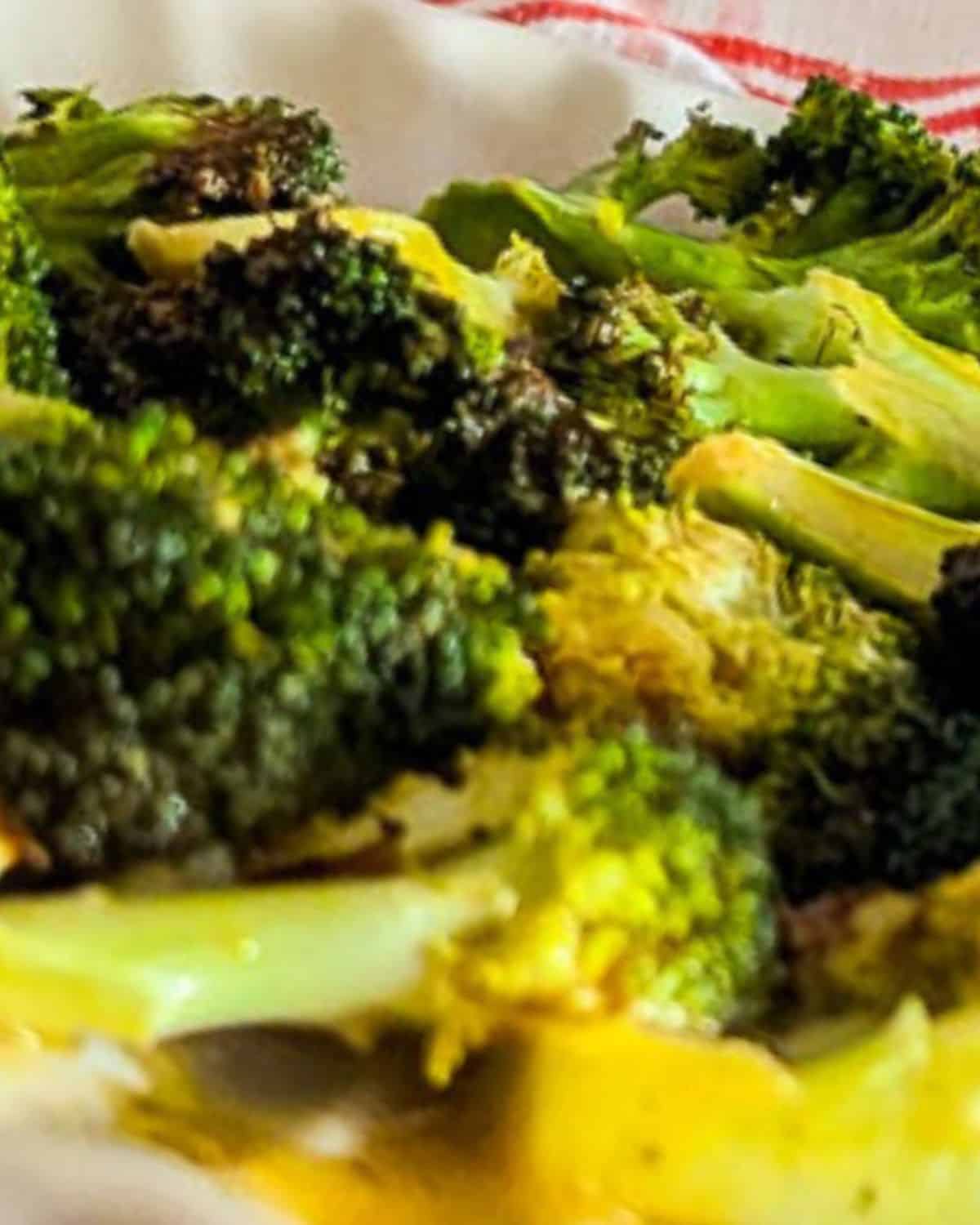 Close-up of crispy air fryer broccoli florets coated in a mustard sauce.