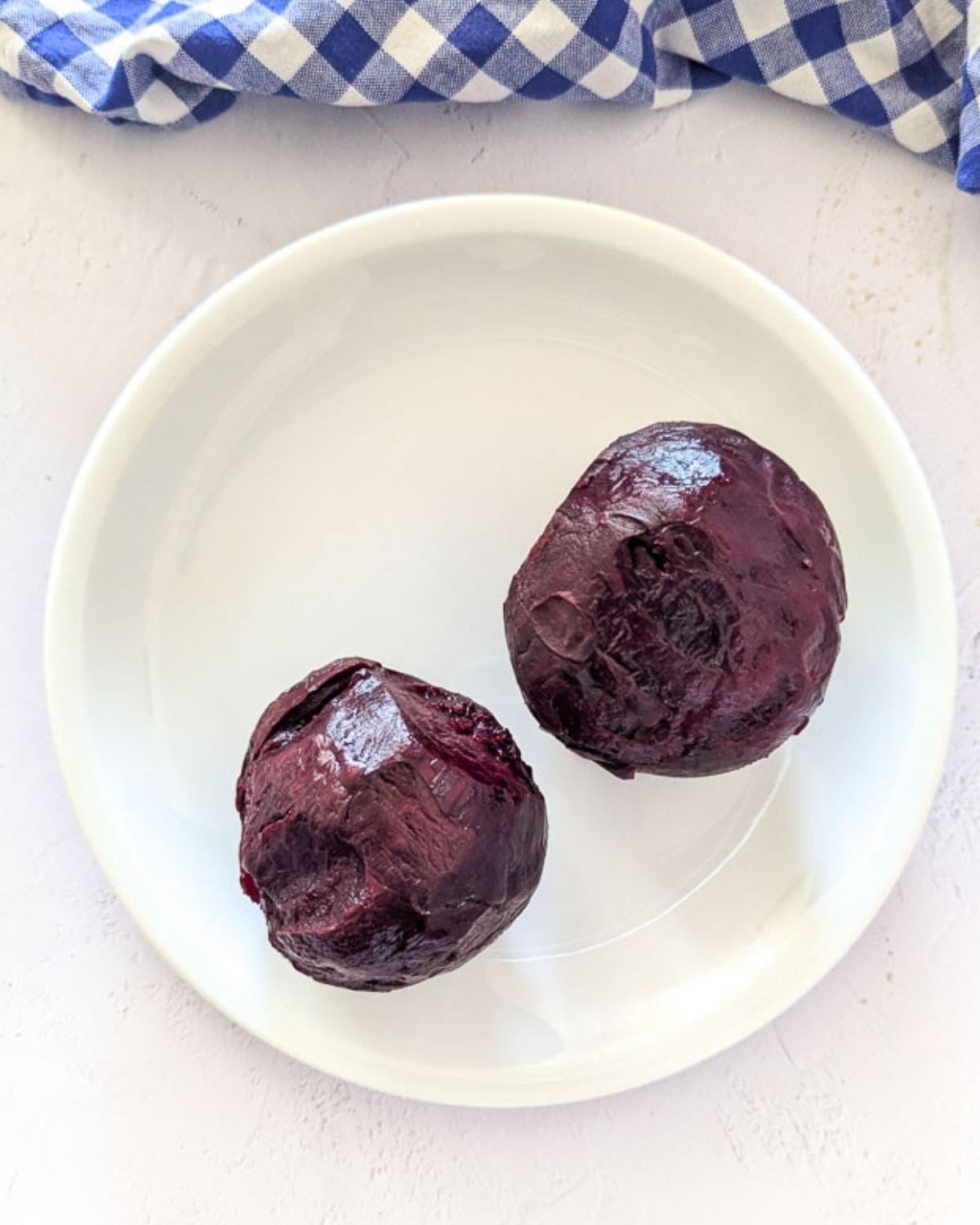 Air fryer roasted and peeled beetroots on a white plate.