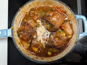South African oxtail simmering in a pot with water and seasoning added.