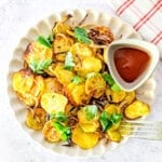Air fried sliced potatoes and onions served with ketchup and parsley.
