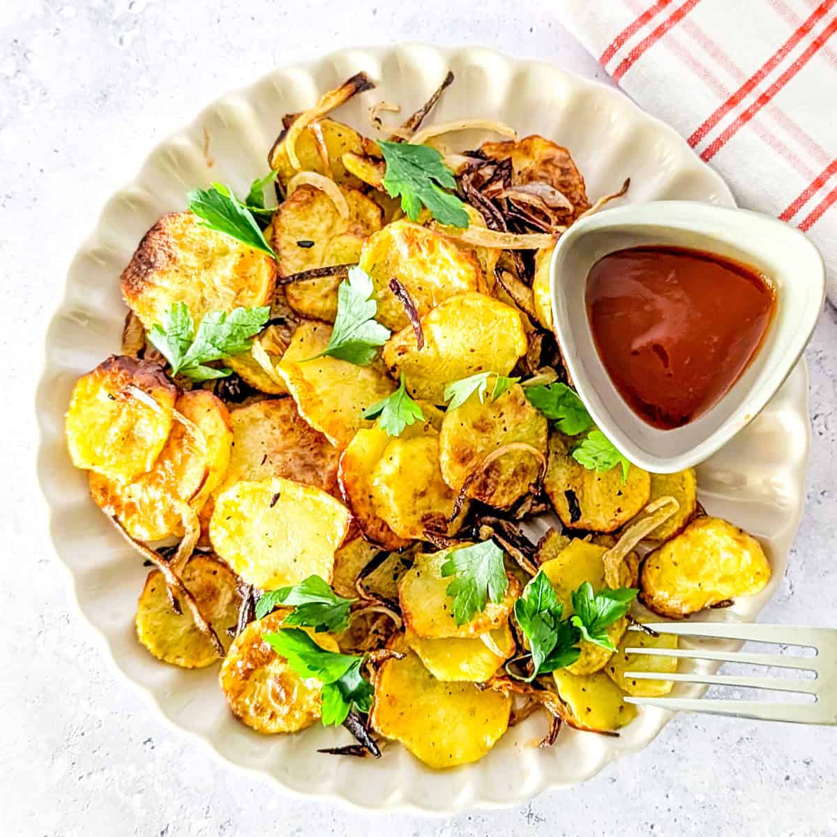 Air fried sliced potatoes and onions served with ketchup and parsley.