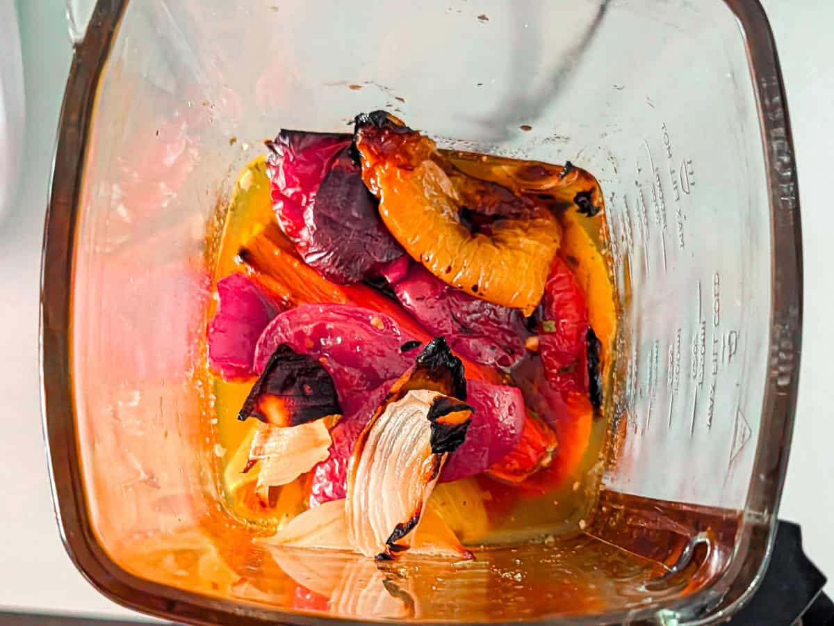 Roasted tomatoes and peppers inside a soup maker jug.